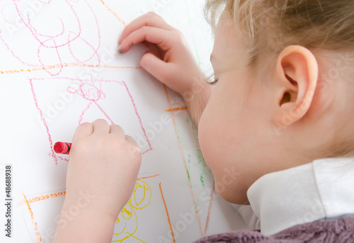 Photo: Cute little girl drawing with pencil Cute little girl drawing with pencil