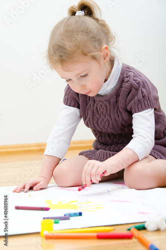 Photo: Cute little girl drawing with pencil Cute little girl drawing with pencil