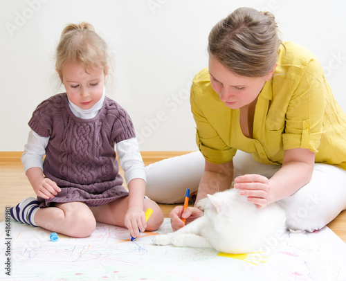 Photo: Young woman and little girl drawing together Young woman and little girl drawing together