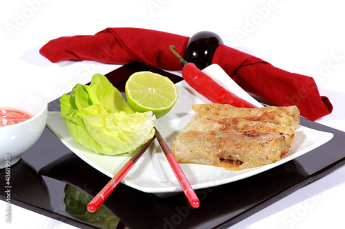 Photo: crispy springrolls on dish with salad isolated on the white crispy springrolls on dish with salad isolated on the white