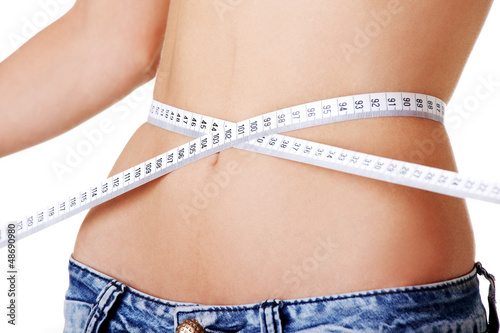 Photo: Young woman measuring her waist Young woman measuring her waist