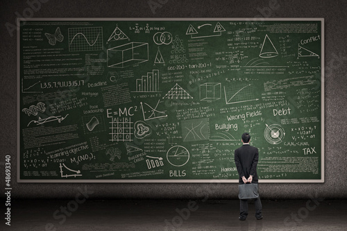 Photo: Businessman looking at hand drawn chalkboard Businessman looking at hand drawn chalkboard