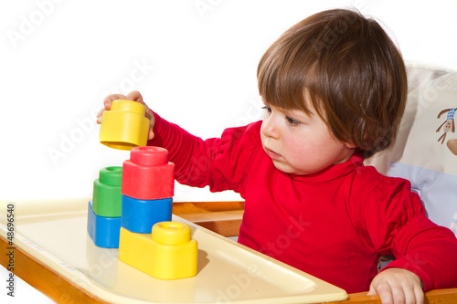 Photo: little girl playing with colorful blocks little girl playing with colorful blocks