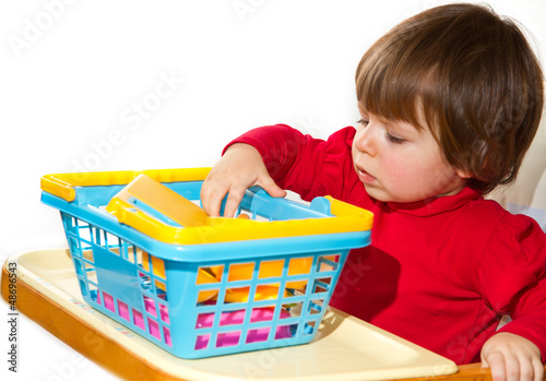 Photo: Little girl playing with colored toys Little girl playing with colored toys
