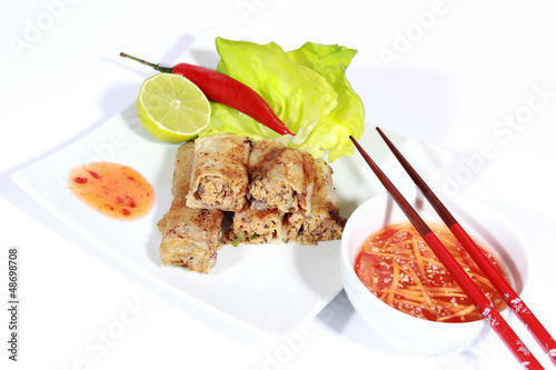 Photo: crispy springrolls on dish with salad isolated on the white crispy springrolls on dish with salad isolated on the white