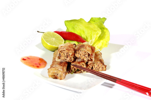 Photo: crispy springrolls on dish with salad isolated on the white crispy springrolls on dish with salad isolated on the white