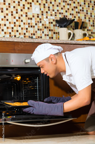 Photo: Asian man baking cake in home kitchen Asian man baking cake in home kitchen