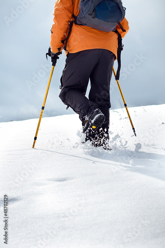 Photo: Hiker walking up on a snow-covered slope Hiker walking up on a snow-covered slope