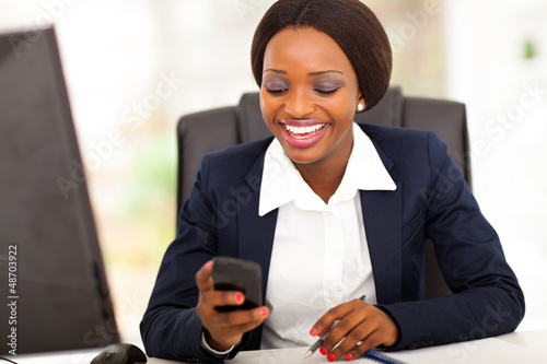 Photo: happy african american busniesswoman reading sms in office happy african american busniesswoman reading sms in office