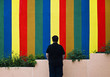 YOUNG MAN IN FRONT OF THE COLORFUL WALL