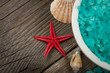 Close-up view from the top on spa salt with seashells.On wood.