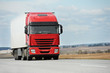 Red lorry with white trailer over blue sky