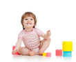 Funny little child is playing with toys while sitting on floor,