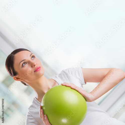 Photo: Portrait of fit and healthy gym woman with ball at fitness club Portrait of fit and healthy gym woman with ball at fitness club