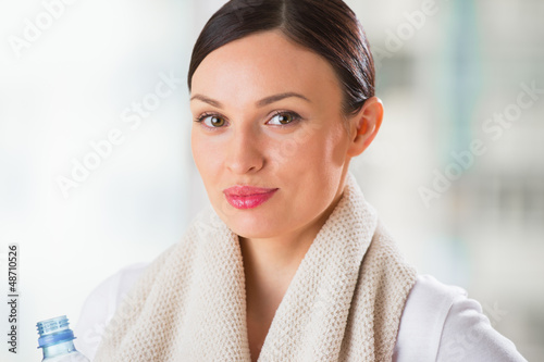 Photo: Portrait of confident young woman in sportswear holding a water Portrait of confident young woman in sportswear holding a water