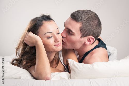 Photo: Happy young couple close up portrait in a romantic mood in bedro Happy young couple close up portrait in a romantic mood in bedro