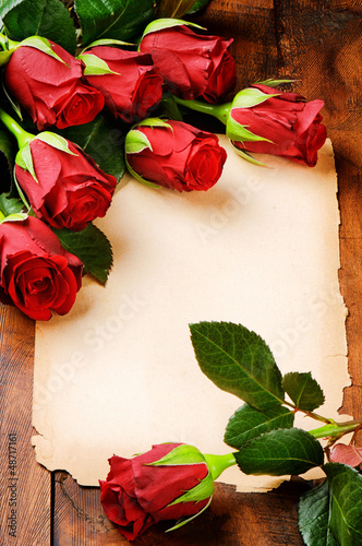 Photo: Frame with red roses and vintage paper Frame with red roses and vintage paper