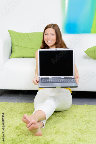 Photo: junge frau hält laptop hoch junge frau hält laptop hoch