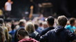 Rearview of a crowd of young people watching a band setting up o