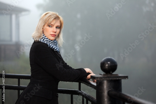 Photo: Young woman against a morning foggy landscape Young woman against a morning foggy landscape