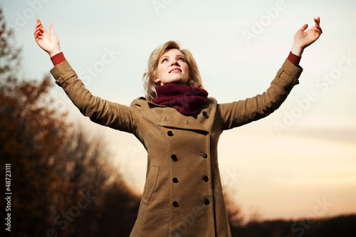 Photo: Woman with arms raised against a sky Woman with arms raised against a sky