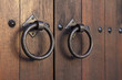 Old medieval metal handles on antique dark wooden door