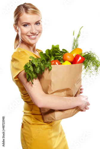 Photo: woman holding a shopping bag full of groceries, mango, salad, r woman holding a shopping bag full of groceries, mango, salad, r
