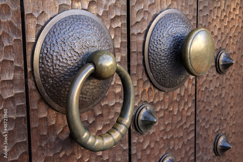 Photo: Medieval metal handle and doorknob on a wooden door Medieval metal handle and doorknob on a wooden door