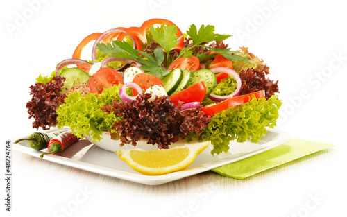 Photo: Vegetable salad bowl isolated on white Vegetable salad bowl isolated on white