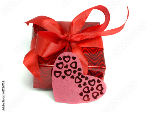 Photo: Red gift tied up by a bow and a card heart Red gift tied up by a bow and a card heart