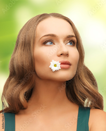 Photo: woman with camomile in mouth woman with camomile in mouth
