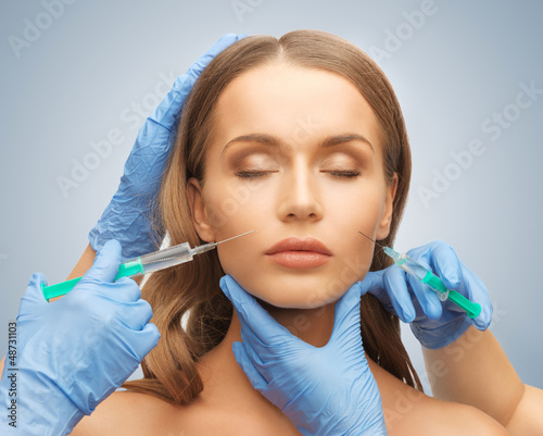Photo: woman face and beautician hands woman face and beautician hands