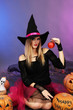 Photo: Halloween witch with red apple on color background Halloween witch with red apple on color background