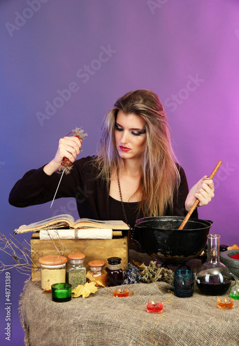 Photo: Halloween witch stirring in poison soup in her cauldron Halloween witch stirring in poison soup in her cauldron