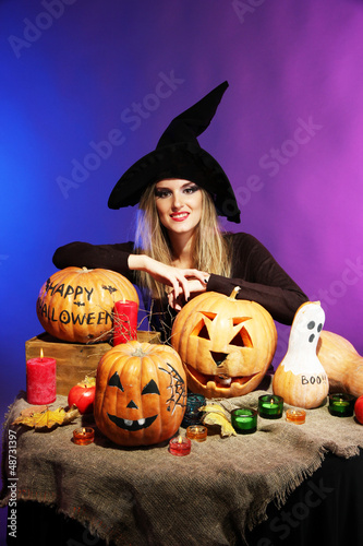 Photo: Halloween witch with pumpkins on color background Halloween witch with pumpkins on color background