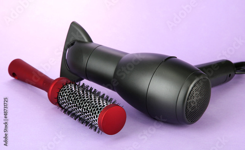 Photo: hair dryer and comb brush, on purple background hair dryer and comb brush, on purple background