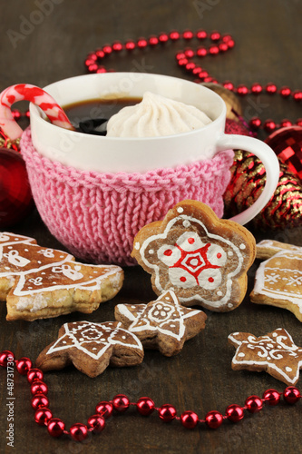 Photo: Cup of coffee with Christmas sweetness on wooden table close-up Cup of coffee with Christmas sweetness on wooden table close-up
