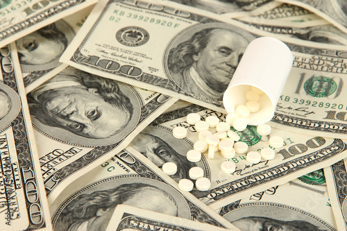 Photo: Pills and money close-up background Pills and money close-up background