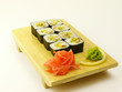Photo: Delicious sushi rolls on wooden plate Delicious sushi rolls on wooden plate