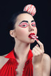 Attractive brunette with candy style makeup eating sweets