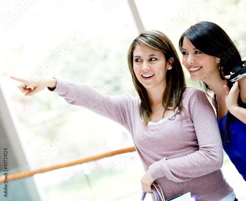 Photo: Shopping women pointing away Shopping women pointing away