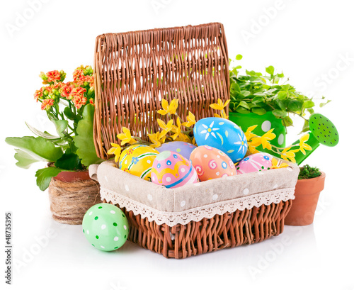 Photo: easter eggs in basket with spring flowers and green leaves easter eggs in basket with spring flowers and green leaves