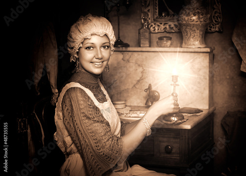 Photo: woman in old cap with candlestick woman in old cap with candlestick