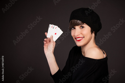 Photo: Smiling girl with french style outfit with four aces Smiling girl with french style outfit with four aces