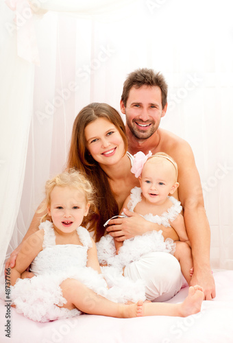 Photo: Happy young family. Indoors. Happy young family. Indoors.