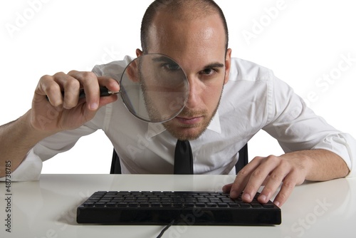 Photo: Businessman looks on the computer with a lens Businessman looks on the computer with a lens