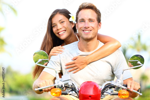 Photo: Happy young couple in love on scooter Happy young couple in love on scooter