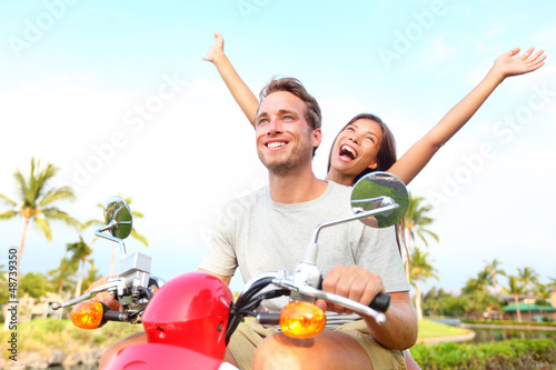 Photo: Happy free freedom couple driving scooter Happy free freedom couple driving scooter