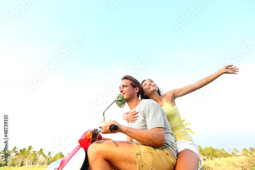 Photo: Young happy free couple in love on scooter Young happy free couple in love on scooter