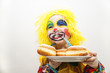 Kleiner Junge als Clown mit Krapfen